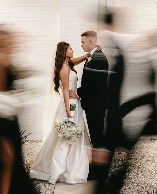 Сouple wearing a white gown and a black suit