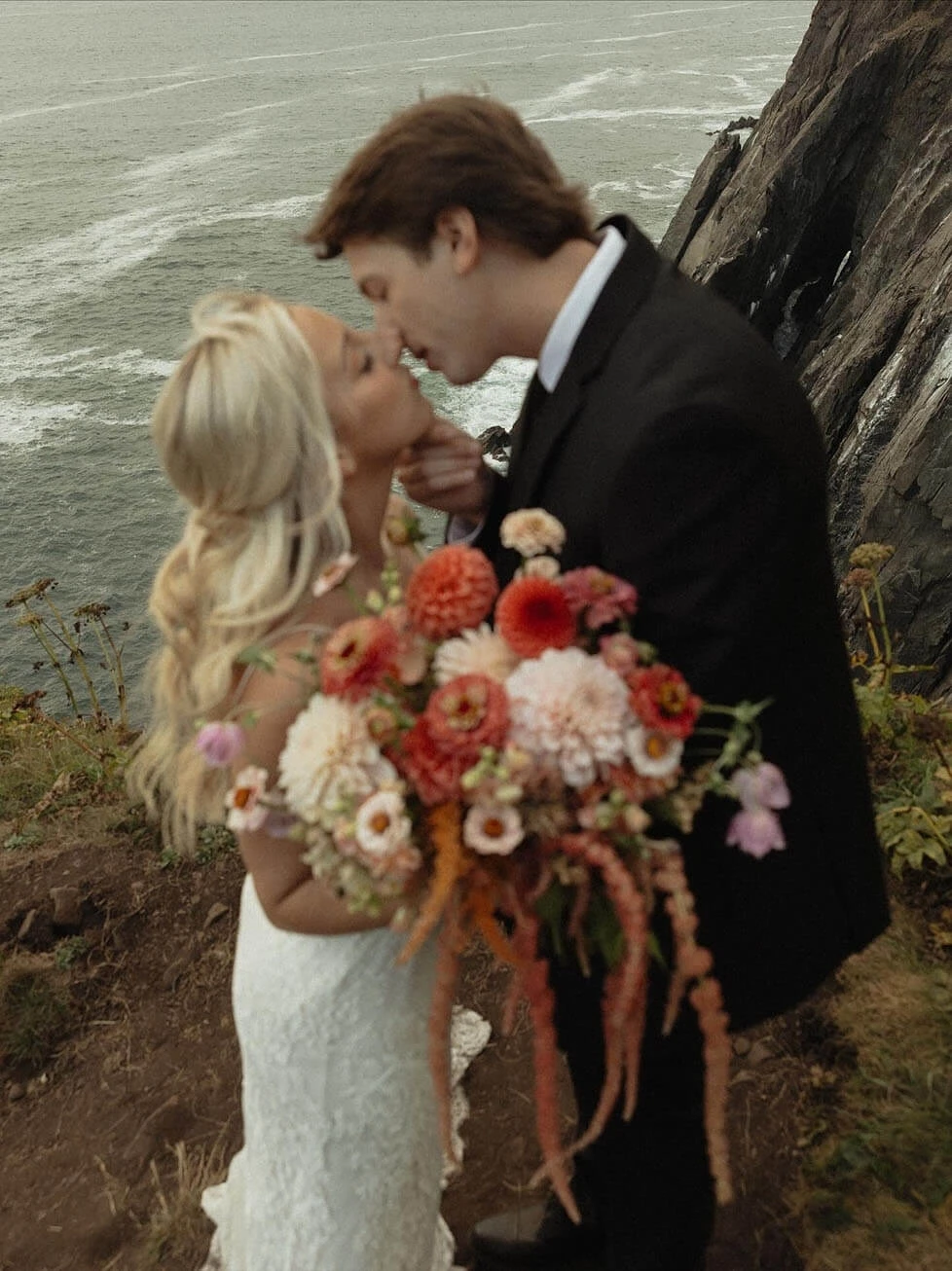 Сouple wearing a white gown and a black suit width flowers